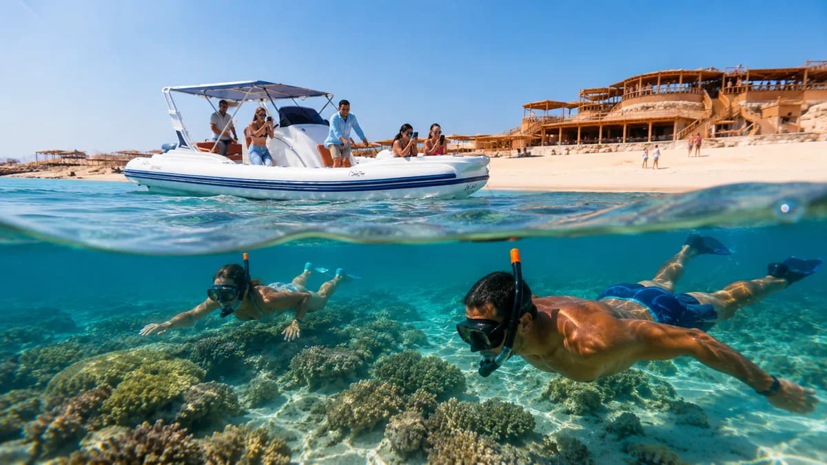 Split over-and-under view of a speedboat moored off Orange Bay with two snorkelers exploring the shallow coral reef below the surface